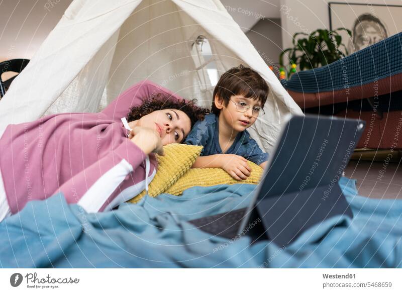 Mutter und Sohn liegen im Spielzelt und schauen einen Film auf dem Tablet Gemeinsam Zusammen Miteinander betrachten betrachtend fernsehen Zelt Zelte
