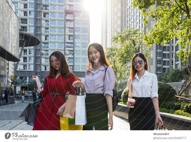 Freundinnen mit Einkaufstüten stehen in der Stadt vor Gebäuden Farbaufnahme Farbe Farbfoto Farbphoto Vietnam Sozialistische Republik Vietnam Asien