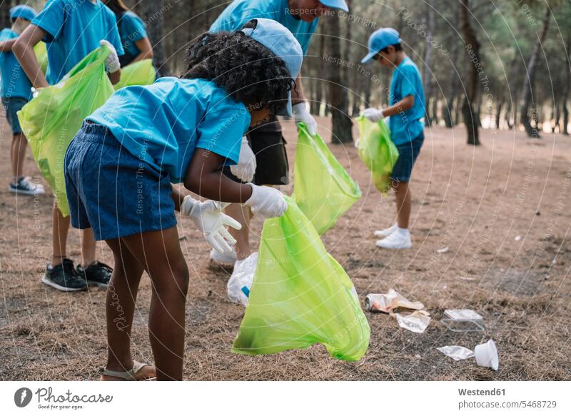 Gruppe von freiwilligen Kindern, die Müll in einem Park sammeln Leute Menschen People Person Personen Europäisch Kaukasier kaukasisch Nordafrikanisch