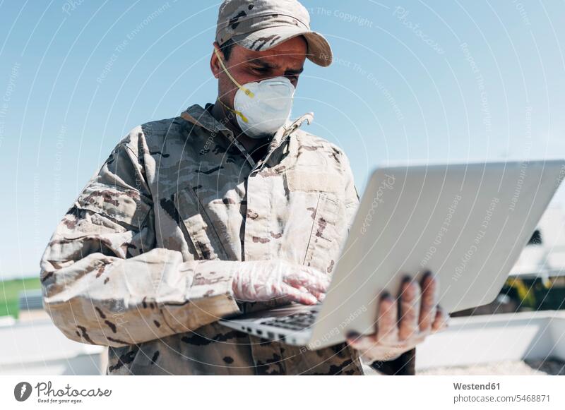 Soldat mit Gesichtsmaske bei Notfalleinsatz, mit Laptop Job Berufe Berufstätigkeit Beschäftigung Jobs Militaer Militär Armeen Heer Heere Soldaten