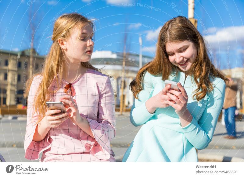 Russland, Moskau, Teenager-Mädchen mit Smartphones Roter Platz beste Freundin beste Freundinnen lächeln fotografieren Teenagerin junges Mädchen Teenagerinnen