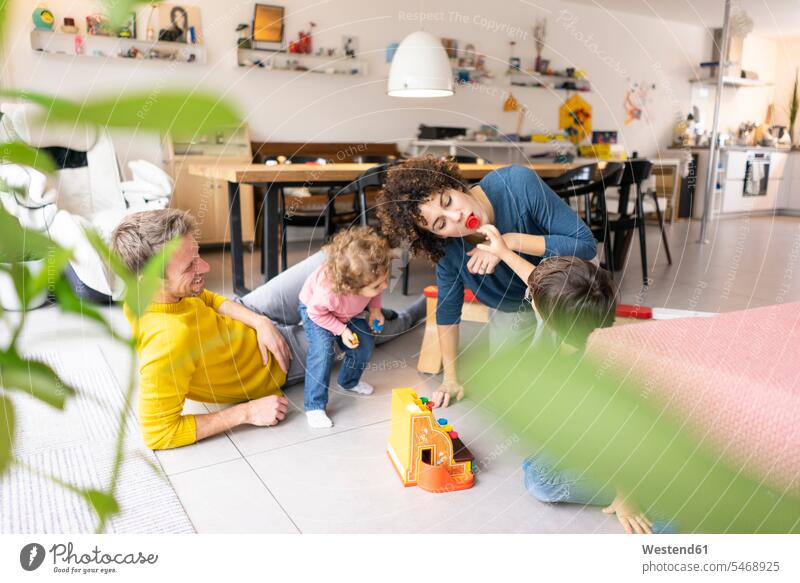 Glückliche Familie spielt mit ihren Kindern am Wochenende spielen Familien Tochter Töchter Spielzeug Zuhause zu Hause daheim Sohn Söhne Mutter Mami Mutti Mütter