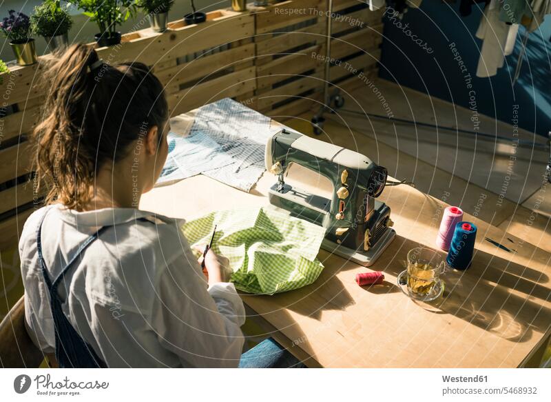 Rückansicht einer Modedesignerin bei der Arbeit in ihrem Atelier Studio Studios Ateliers Arbeitstisch Arbeitstische Modedesignerinnen arbeiten Unabhängigkeit