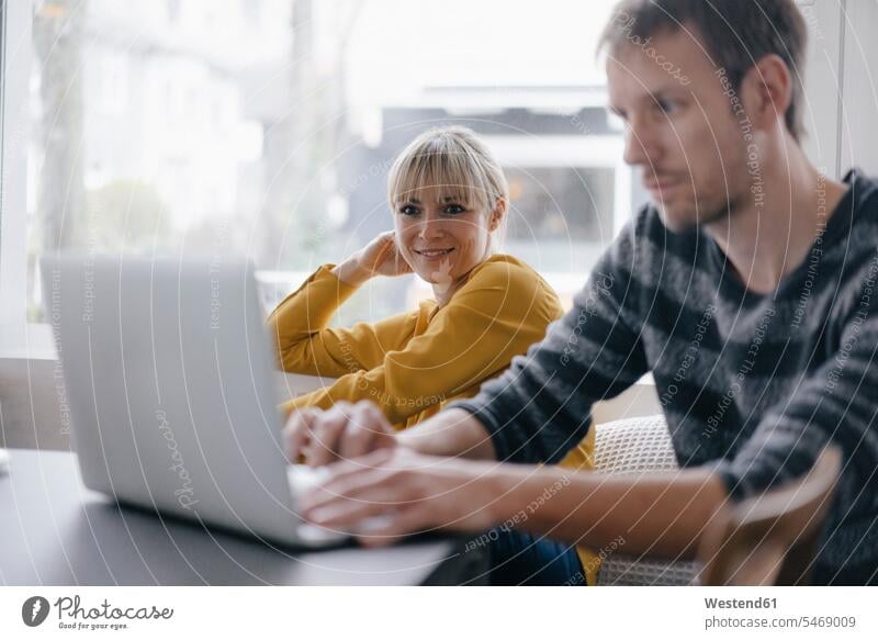 Mann und Frau sitzen am Tisch und benutzen einen Laptop Laptop benutzen Laptop benützen Geschäftsfrau Geschäftsfrauen Businesswomen Businessfrauen Businesswoman