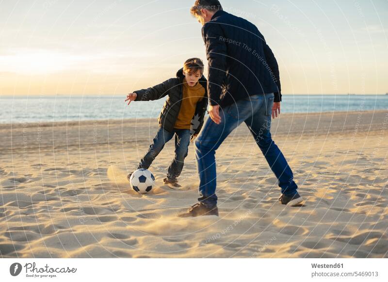 Vater und Sohn spielen am Strand Fussball Fußball Fußbälle Papas Väter Vati Vatis Papis Beach Straende Strände Beaches Söhne Ball Bälle Eltern Familie Familien