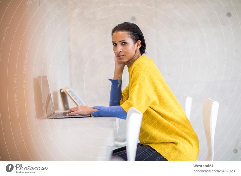 Porträt einer jungen Frau in gelbem Pullover mit Laptop Notebook Laptops Notebooks benutzen benützen gelber gelbes weiblich Frauen Portrait Porträts Portraits