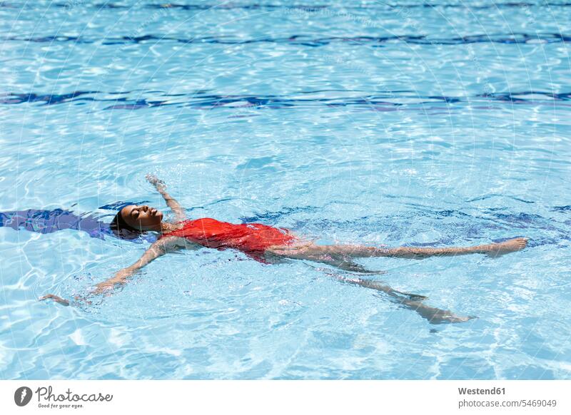 Junge Frau schwimmt im Schwimmbad auf dem Wasser Leute Menschen People Person Personen Afrikanisch Afrikanische Abstammung dunkelhäutig Farbige Farbiger