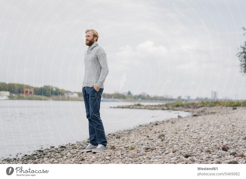 Deutschland, Düsseldorf, entspannter Mann steht am Flussufer und schaut auf die Aussicht entspanntheit relaxt Ausblick Ansicht Überblick Männer männlich stehen