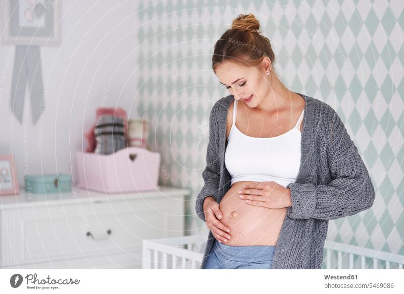 Schwangere Frau streichelt Babybauch weiblich Frauen Kinderzimmer schwanger schwangere Frau Bauch Bäuche Erwachsener erwachsen Mensch Menschen Leute People