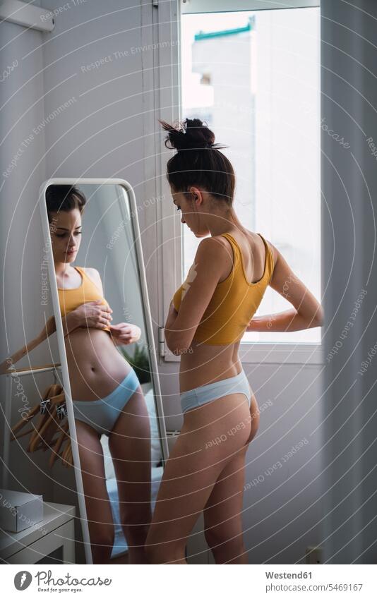 Junge Frau in Unterwäsche zu Hause in den Spiegel schauen Zuhause daheim schön weiblich Frauen sehend Erwachsener erwachsen Mensch Menschen Leute People