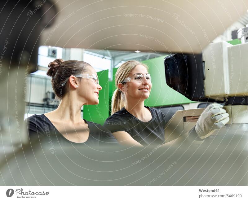 Zwei Frauen arbeiten an einer Maschine Österreich Schutzhandschuh Schutzhandschuhe Männerberuf Arbeiterin Arbeiterinnen Metallverarbeitung Kompetenz Fähigkeit