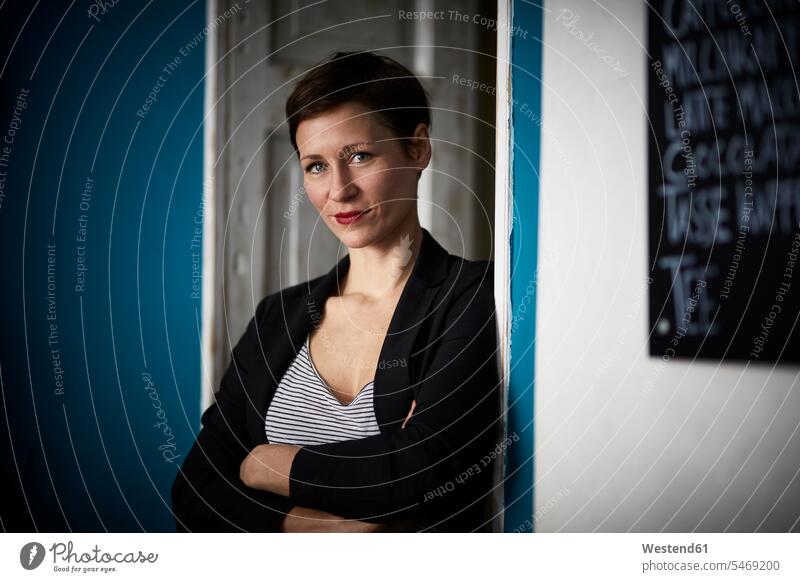 Porträt einer Geschäftsfrau, die sich in der Tür lehnt Geschäftsfrauen Businesswomen Businessfrauen Businesswoman Portrait Porträts Portraits Türen