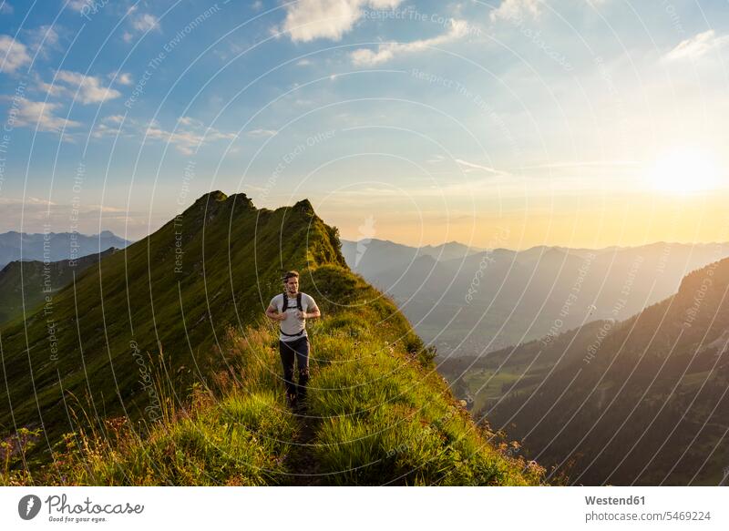 Deutschland, Bayern, Oberstdorf, Mann wandert auf einem Bergrücken in den Bergen bei Sonnenuntergang Männer männlich Sonnenuntergänge Grat Bergruecken wandern