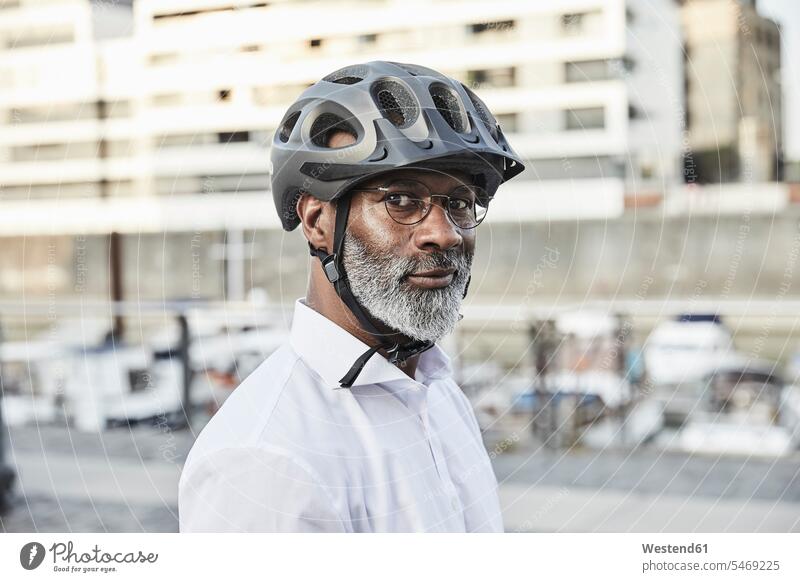 Porträt eines reifen Geschäftsmannes mit grauem Bart, der einen Fahrradhelm und eine Brille trägt geschäftlich Geschäftsleben Geschäftswelt Geschäftsperson