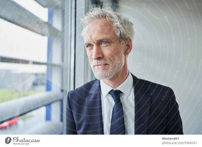 Porträt eines Geschäftsmannes, der aus dem Fenster schaut Job Berufe Berufstätigkeit Beschäftigung Jobs geschäftlich Geschäftsleben Geschäftswelt