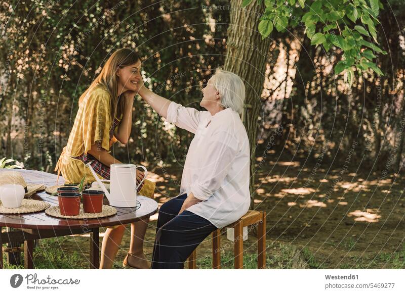 Mutter berührt das Gesicht der Tochter, während sie im Hof sitzt Farbaufnahme Farbe Farbfoto Farbphoto Spanien Freizeitbeschäftigung Muße Zeit Zeit haben