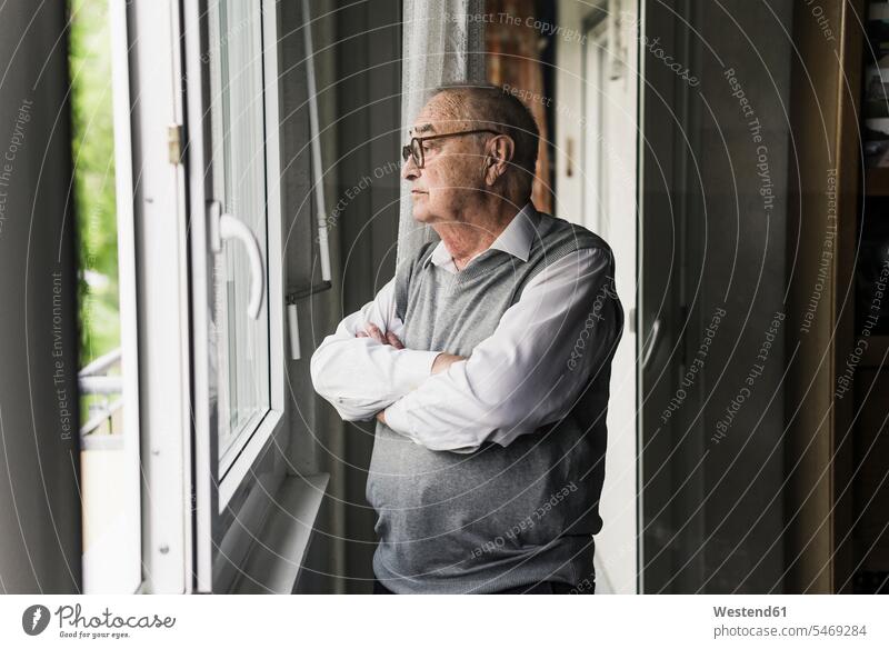 Nachdenklicher älterer Mann schaut aus dem Fenster Leute Menschen People Person Personen Alleinstehende Alleinstehender Singles Unverheiratete Unverheirateter
