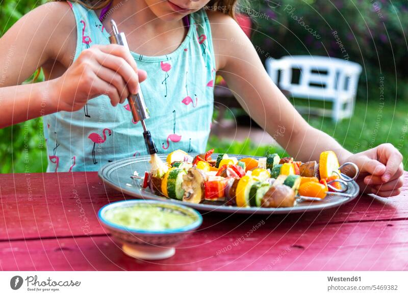 junges Mädchen bestreicht vegetarische Grillspieße mit argentinischem Chimichurri zubereiten kochen Essen zubereiten Spieß Spieße Spiess Spiesse