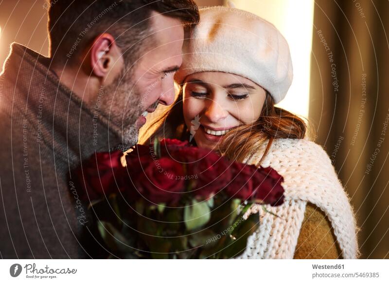Verliebtes Paar mit Strauß roter Rosen im Winter winterlich Winterzeit Pärchen Paare Partnerschaft verliebt Blumenstrauß Bouquet Blumenstrauss Blumensträusse
