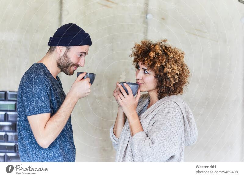 Mann und Frau trinken Kaffee und lächeln sich gegenseitig an weiblich Frauen Männer männlich ansehen Erwachsener erwachsen Mensch Menschen Leute People Personen
