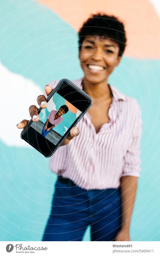 Frau zeigt ihr Selfie auf dem Smartphone Bilder Bildnis Fotos Telekommunikation telefonieren Handies Handys Mobiltelefon Mobiltelefone Displays freuen Glück