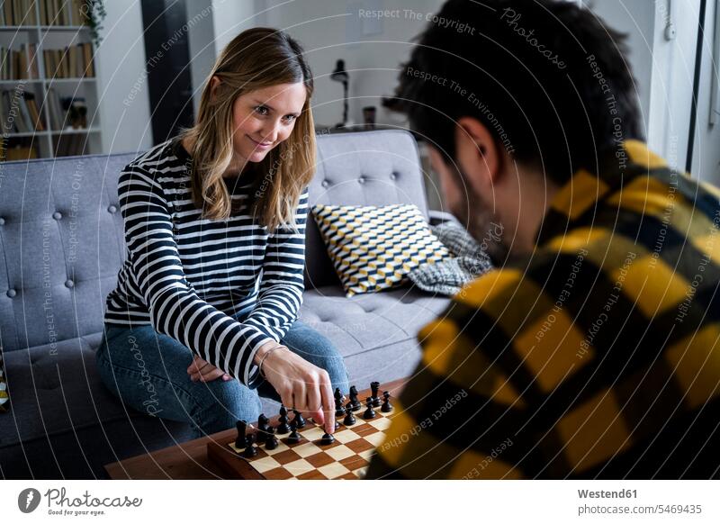 Frau und Mann spielen Schach zu Hause Innenaufnahme Innenaufnahmen innen drinnen Tag Tageslichtaufnahme Tageslichtaufnahmen Tagesaufnahme am Tag Tagesaufnahmen