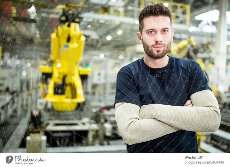 Porträt eines selbstbewussten Arbeiters in einer modernen Fabrik Job Berufe Berufstätigkeit Beschäftigung Jobs T-Shirts zufrieden stehend steht Arbeitsstätte