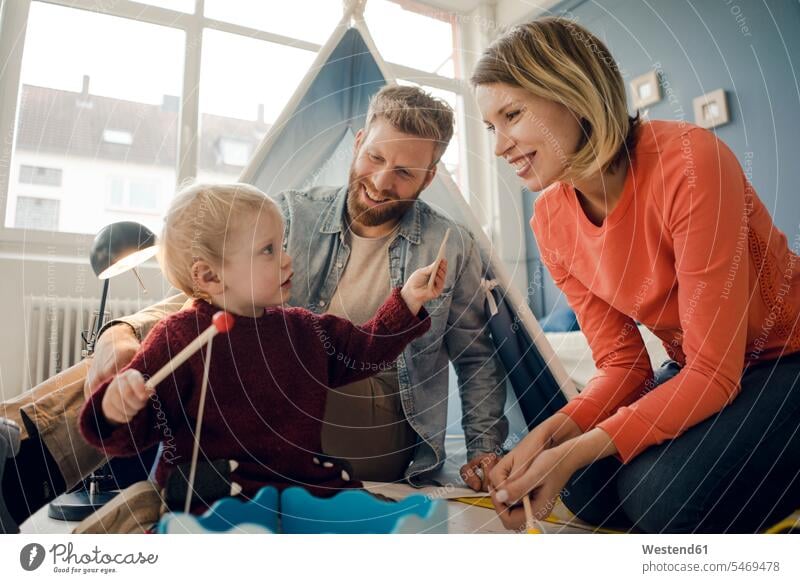 Glückliche Familie spielt mit ihrem Sohn zu Hause Familien spielen Unbeschwert Sorglos Zuhause daheim greifen Griff lachen zelten Spielzeug Zelt Zelte glücklich