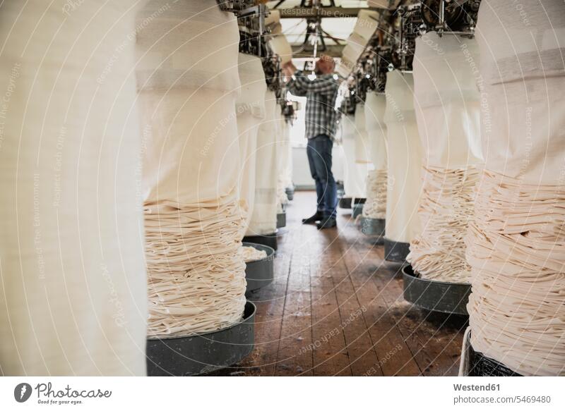 Arbeiter einstellende Rundstrickmaschine, Garn einfädeln Job Berufe Berufstätigkeit Beschäftigung Jobs Textilien Gewebe Stoffe Textilfasern weiss weiße weißer