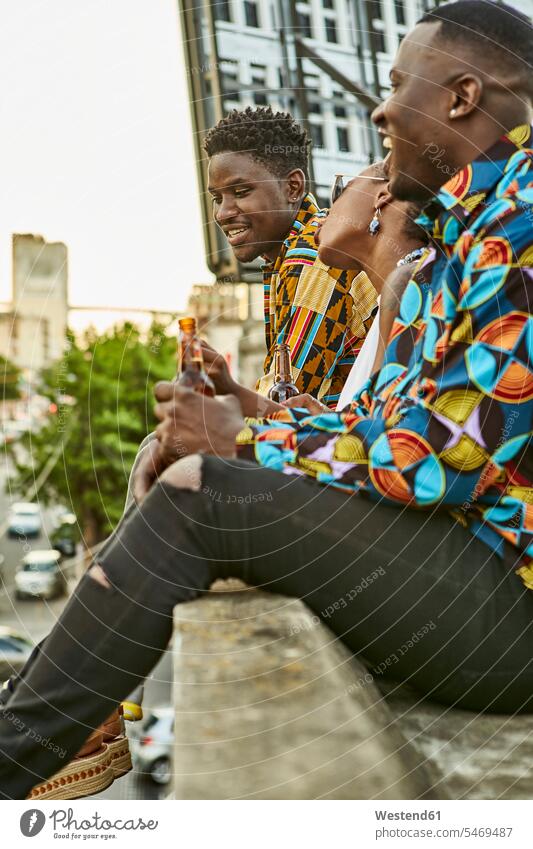 Freunde sitzen auf der Dachterrasse in der Stadt und trinken Bier, Maputo, Mosambik Kameradschaft Flaschen Bierflaschen Hemden sitzend sitzt entspannen relaxen