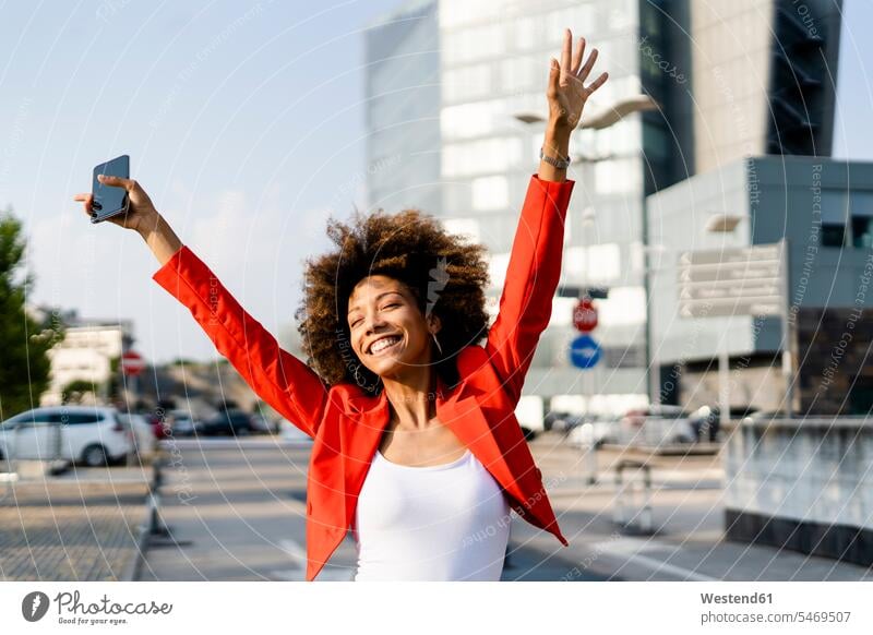 Porträt einer glücklichen jungen Frau mit Smartphone in modischer roter Anzugsjacke Telekommunikation Handies Handys Mobiltelefon Mobiltelefone entspannen