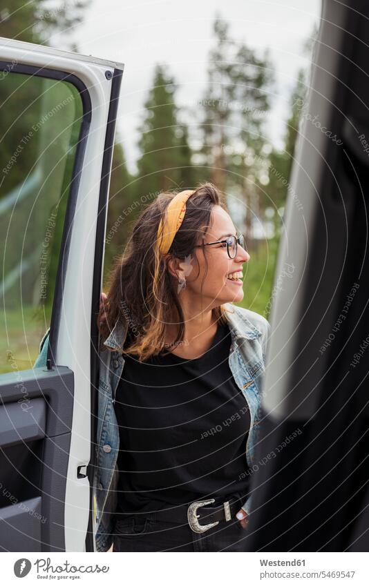 Finnland, Lappland, glückliche junge Frau an einem Auto in ländlicher Landschaft Glück glücklich sein glücklichsein weiblich Frauen Wagen PKWs Automobil Autos