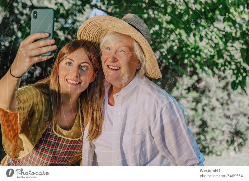Lächelnde mittelgroße Frau, die sich mit ihrer Mutter im Hof selbstständig macht Farbaufnahme Farbe Farbfoto Farbphoto Spanien Freizeitbeschäftigung Muße Zeit