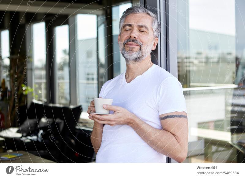 Mann steht beim Franzosen und genießt eine Tasse Kaffee Kaffeetasse Kaffeetassen genießen geniessen Genuss stehen stehend Fenstertür Tassen lächeln Ruhe