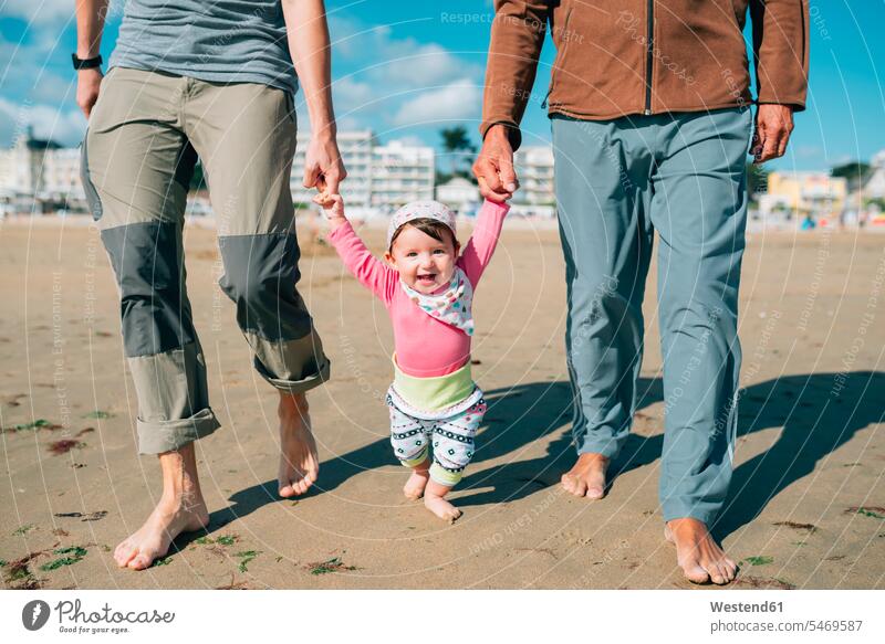 Frankreich, La Baule, Porträt eines glücklichen Mädchens, das mit Vater und Großvater am Strand spazieren geht gehen gehend Glück glücklich sein glücklichsein