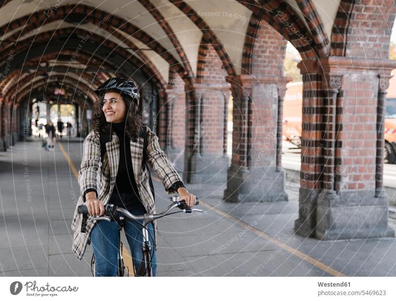 Glückliche Fahrrad fahrende Frau in der Stadt, Berlin, Deutschland Raeder Räder Bike Bikes Fahrräder Rad verreisen freuen Frohsinn Fröhlichkeit Heiterkeit