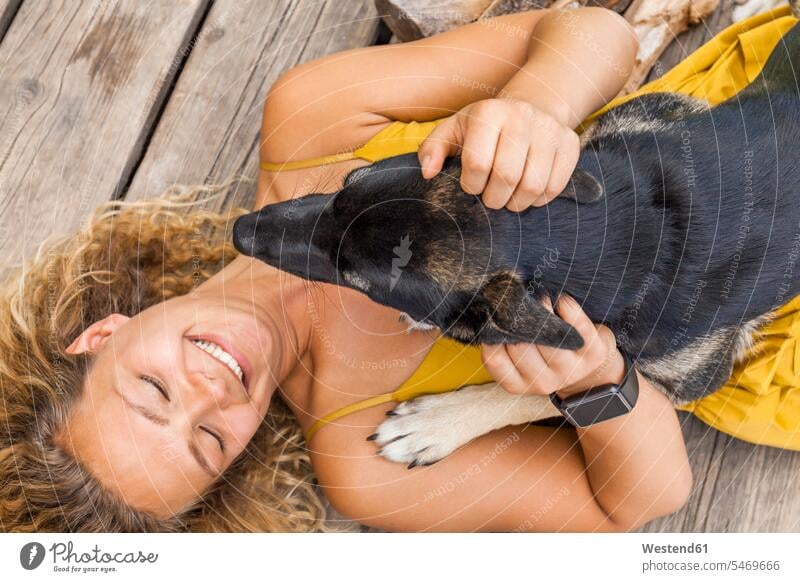 Husky-Schäferhund-Mischling und sein Frauchen auf Holzbrett liegend Tiere Tierwelt Haustiere Hunde Uhren Armbanduhren knuddeln schmusen sitzend sitzt freuen
