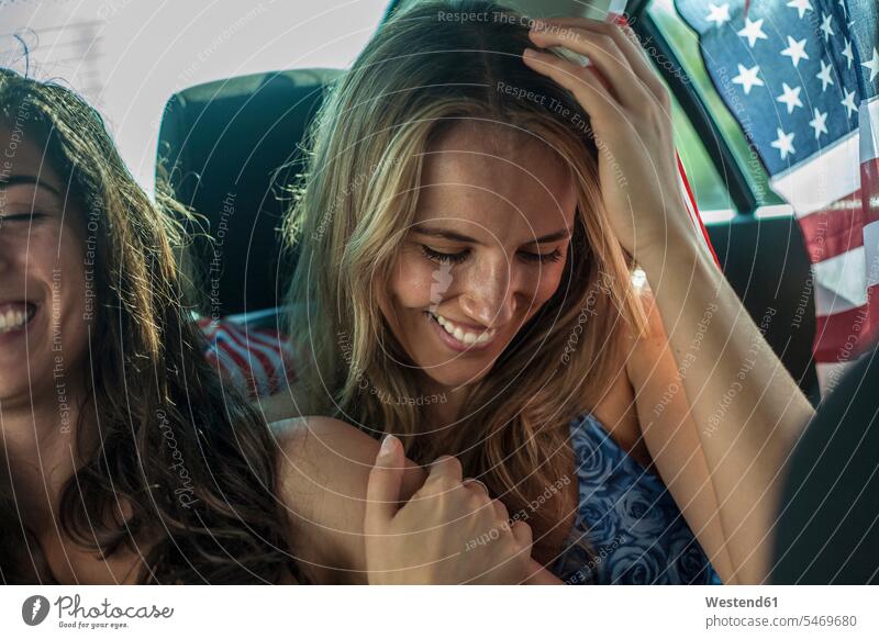 Lächelnde Freundinnen, die während einer Autofahrt im Auto sitzen Farbaufnahme Farbe Farbfoto Farbphoto Haltung innere Haltung Einstellung Geisteshaltung