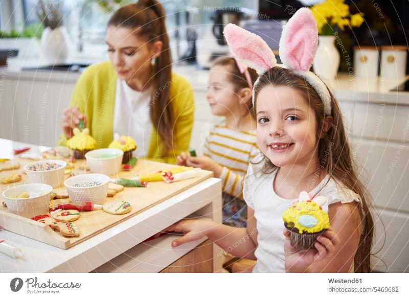 Porträt eines lächelnden Mädchens zeigt Osterkuchen in der Küche Portrait Porträts Portraits Ostern Osterfest Cupcake Cup Cake Cupcakess Cup Cakes weiblich