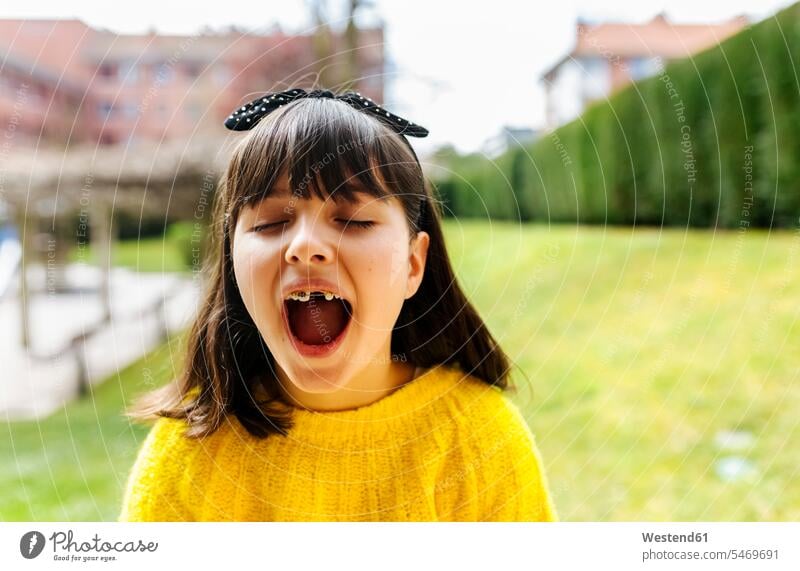 Porträt eines Mädchens mit Zahnspange im Freien Schleifen freuen Glück glücklich sein glücklichsein zufrieden Farben Farbtoene Farbton Farbtöne gelbe gelber