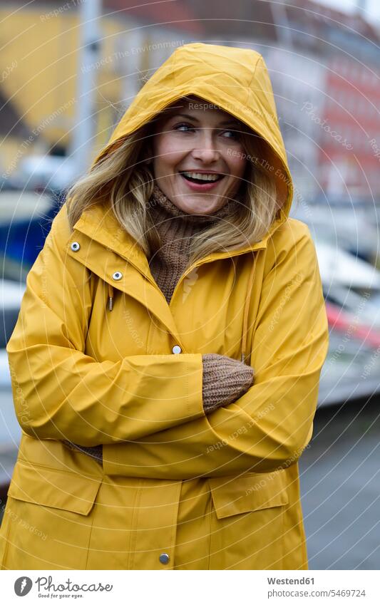 Dänemark, Kopenhagen, Porträt einer glücklichen Frau am Stadthafen bei regnerischem Wetter Glück glücklich sein glücklichsein Portrait Porträts Portraits Hafen