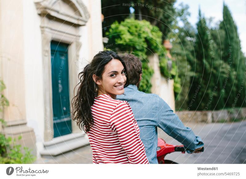 Lächelnde Frau sitzt mit Freund auf Vespa Farbaufnahme Farbe Farbfoto Farbphoto Toskana Italien Tourismus Freizeitbeschäftigung Muße Zeit Zeit haben