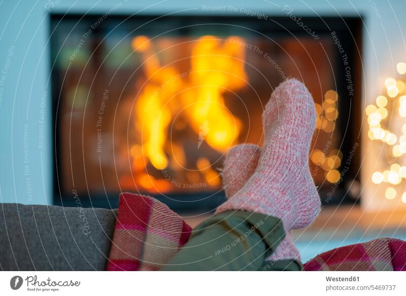Beine einer jungen Frau mit Socken, die sich zu Hause am Kamin entspannen Farbaufnahme Farbe Farbfoto Farbphoto Deutschland Freizeitbeschäftigung Muße Zeit