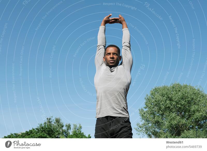 Sportler streckt seine Arme aus Workout Dehnübung Gesunder Lebensstil Gesundheitsbewusstsein gesunde Lebensweise sportlich aufwärmen sich aufwärmen