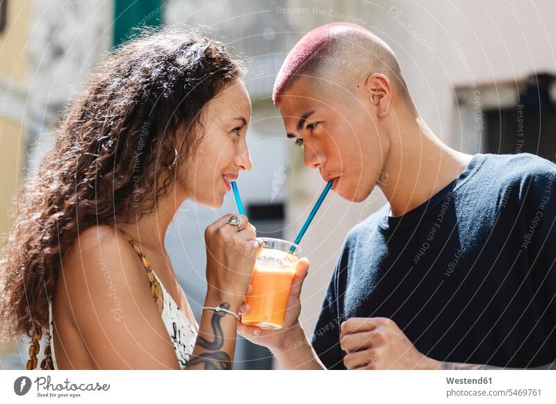 Junges Paar trinkt gemeinsam Fruchtsaft Touristen Strohhalme Trinkhalm Trinkhalme freuen Glück glücklich sein glücklichsein gefühlvoll Emotionen Empfindung