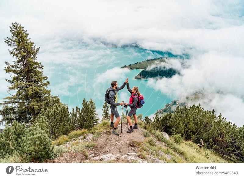 Glückliches junges Paar auf einer Wanderung im Hochfeuer der Berge, Herzogstand, Bayern, Deutschland Leute Menschen People Person Personen Europäisch Kaukasier