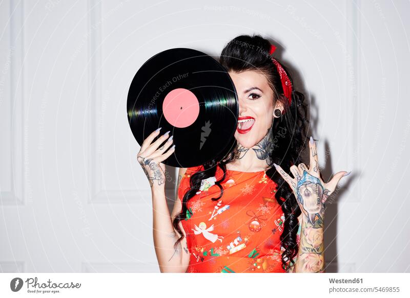 Porträt einer tätowierten Frau mit Platte mit Rock And Roll-Zeichen rock 'n' roll weiblich Frauen Schallplatte Vinyl Schallplatten Tattoo Tätowierungen Tatoos