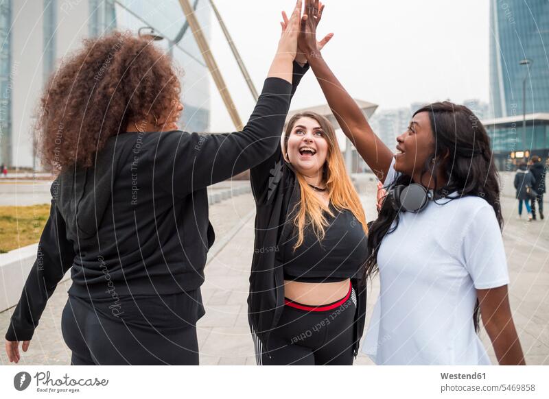 Drei sportliche junge Frauen in der Stadt Leute Menschen People Person Personen Europäisch Kaukasier kaukasisch Afrikanisch Afrikanische Abstammung dunkelhäutig