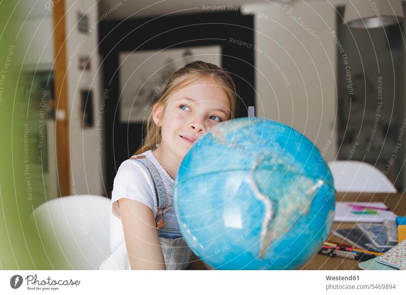 Porträt eines selbstbewussten Mädchens mit Globus zu Hause, das in die Ferne schaut Leute Menschen People Person Personen Europäisch Kaukasier kaukasisch 1 Ein