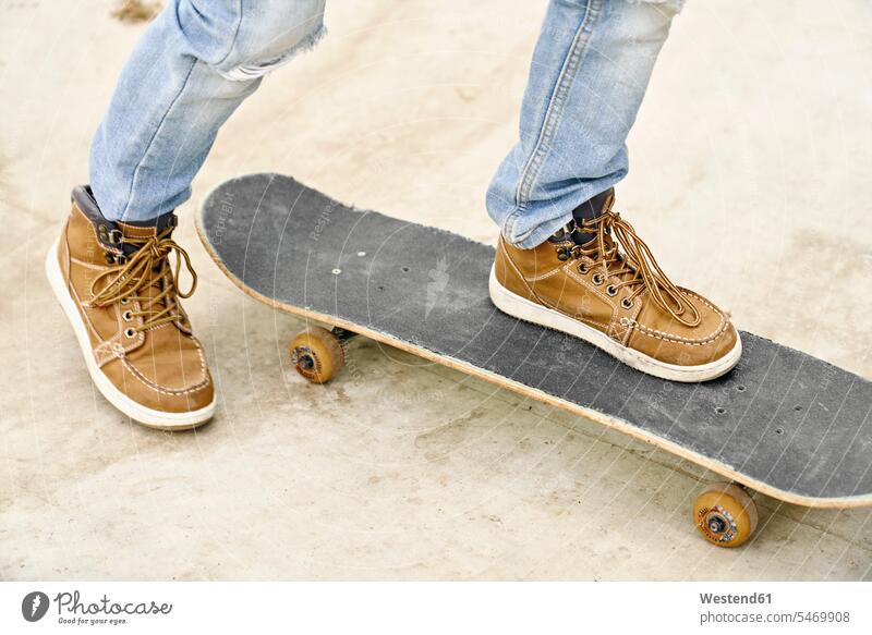 Füße auf Skateboard skateboarden Junge Buben Knabe Jungen Knaben männlich Lederschuhe stehen stehend steht Rollbretter Skateboards Skateboarden Skateboardfahren